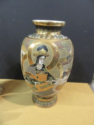 a gold vase with a picture of a woman on it