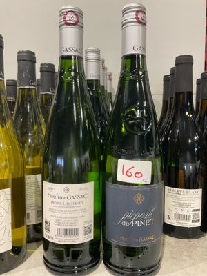 Des bouteilles de vin sont alignées sur le comptoir d'un caviste.
