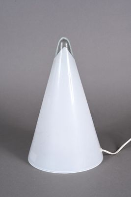 une lampe blanche en forme de cône posée sur une table