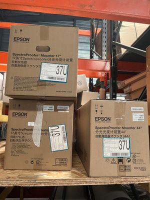 Des cartons contenant des imprimantes Epson sont empilés sur une palette dans un entrepôt