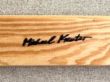 a wooden baseball bat with a signature on it