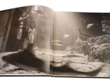 a black and white photo of a book opened to show a picture of a man and a woman
