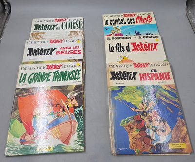 Plusieurs bandes dessinées sont alignées sur une table devant un ordinateur portable