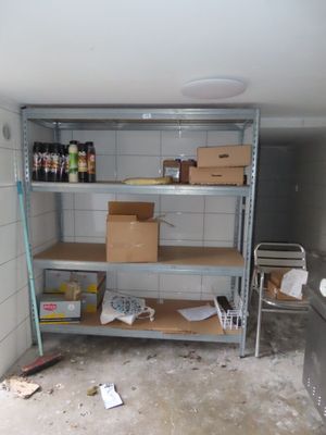 une pièce avec des étagères et des cartons posés par terre