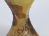 a glass vase with flowers on it on a white surface