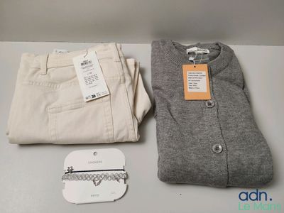 deux pantalons et un pull posés sur une table