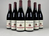 six bouteilles de vin sont alignées sur une table
