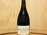 une bouteille de vin posée sur un tonneau en bois