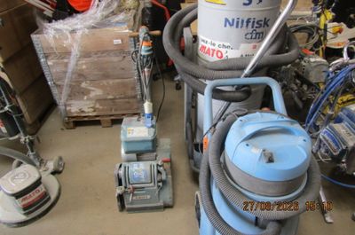 une photo d'une pièce où se trouvent un aspirateur et d'autres objets