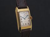 an image of a gold plated wrist watch with a brown leather strap