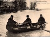 trois hommes dans une barque à rames dans une rue inondée