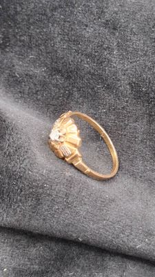 une bague en or surmontée d'une fleur