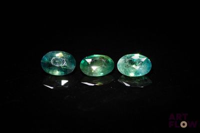 trois saphirs verts sur fond noir