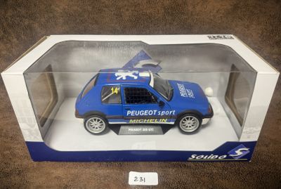 une petite voiture bleue dans une boîte posée par terre