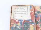 an old book that is open on a white surface