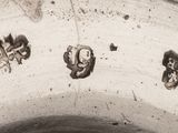 a close up of a silver vase with three birds on it