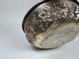 a silver vase sitting on top of a white table