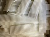 a cardboard box filled with a bunch of white toothbrushes