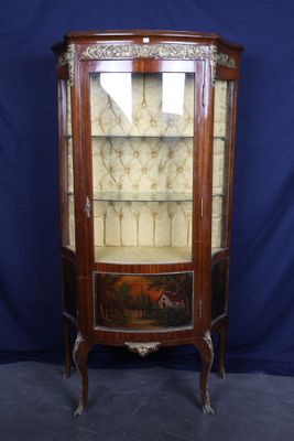 une vitrine ancienne en bois, dotée de portes vitrées et de tiroirs