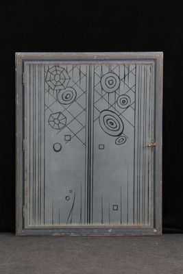 une porte vitrée sur laquelle est dessiné un motif, dans une pièce