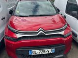 La voiture rouge est garée à côté de la camionnette blanche.