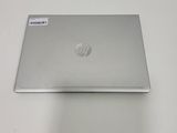 a silver laptop on a white table with a sticker on it