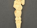 a carved ivory figurine of a man holding a pipe