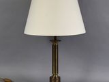 une lampe de table en laiton avec un abat-jour blanc sur fond gris