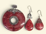 a picture of a jewelry set with a red stone