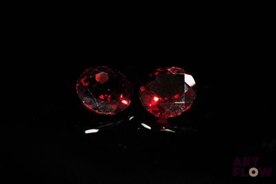 une paire de boucles d'oreilles à clous en cristal rouge sur fond noir