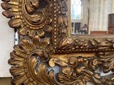 a gold mirror on the wall in a room