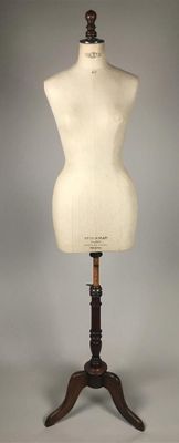 an image of a mannequin on a wooden stand with a gray background