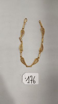 gros plan d'un collier en or sur fond blanc
