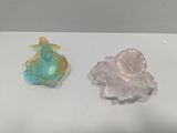 two small glass figurines sitting on a table