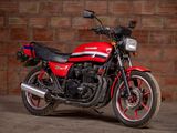 a red and black motorcycle parked in front of a brick wall