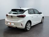 the back end of a white car in a room with a black floor