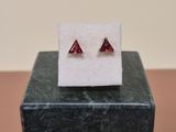 a pair of red garnets sit on top of a black marble block