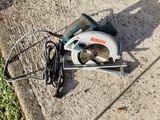a corded circular saw on the ground next to a corded circular saw