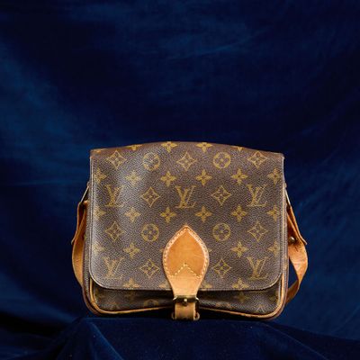 un sac à bandoulière vintage Louis Vuitton sur fond bleu