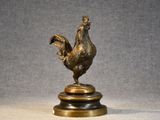 statue of a rooster on a pedestal on a gray background