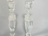 pair of clear glass candlesticks sitting on top of a table