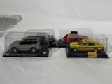 three toy cars in a display case on a white surface