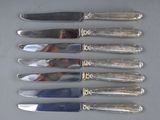 six knives that are sitting on a table
