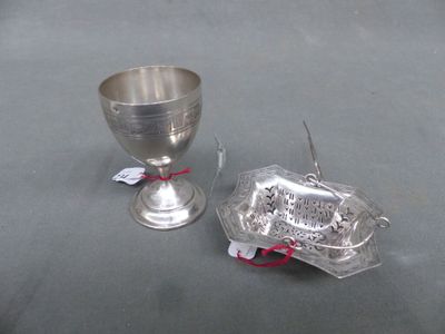 a silver cup sitting next to a silver cup on a table