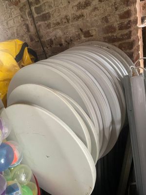 a pile of white plates and plastic cups in a room