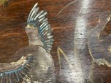a close up of a wooden table with a bird painted on it