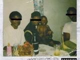 two men and a baby sitting at a table with a bottle of wine