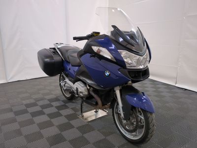 une moto bleue garée sur un sol à carreaux noirs et blancs