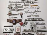 de nombreux types d'emblèmes automobiles exposés sur le mur