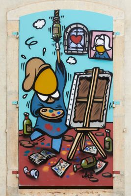 graffiti painting of a man painting a picture on a wall